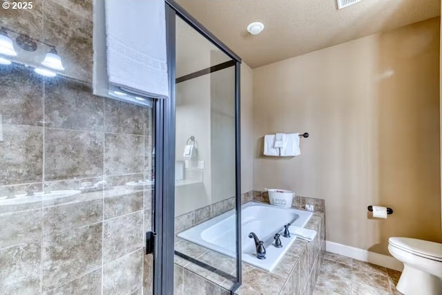 547 Front St, Rockaway Beach, OR 97136 - bathroom with a textured ceiling, a relaxing tiled tub, and toilet