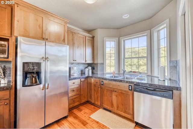 547 Front St, Rockaway Beach, OR 97136 - kitchen featuring decorative backsplash, stainless steel appliances, light hardwood / wood-style floors, and sink
