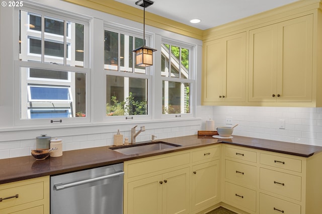2603 NE 11th Ave, Portland, OR 97212 - kitchen featuring stainless steel dishwasher, cream cabinetry, dark countertops, and backsplash