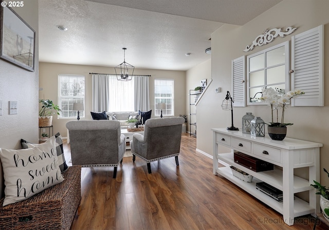 living room featuring wood finished floors, baseboards, and a textured ceiling