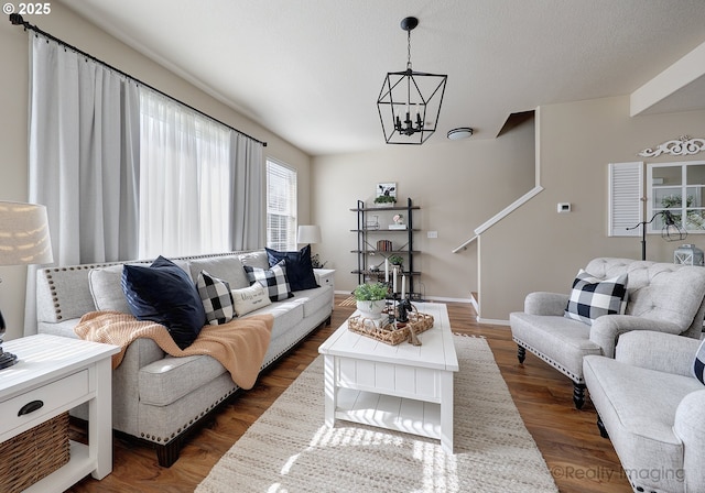 living room featuring baseboards, a notable chandelier, and dark wood finished floors