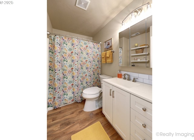 full bath featuring visible vents, toilet, and wood finished floors