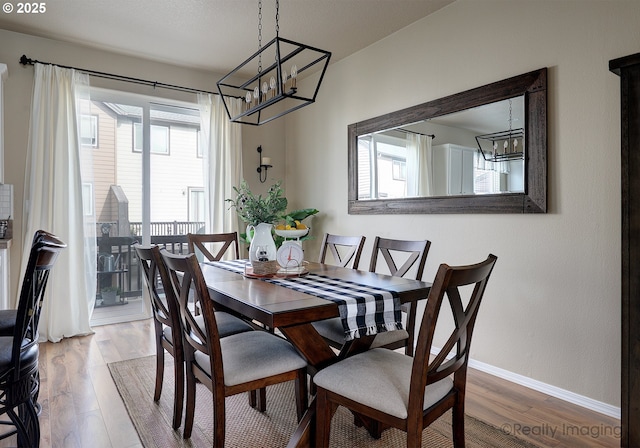 dining space with wood finished floors and baseboards