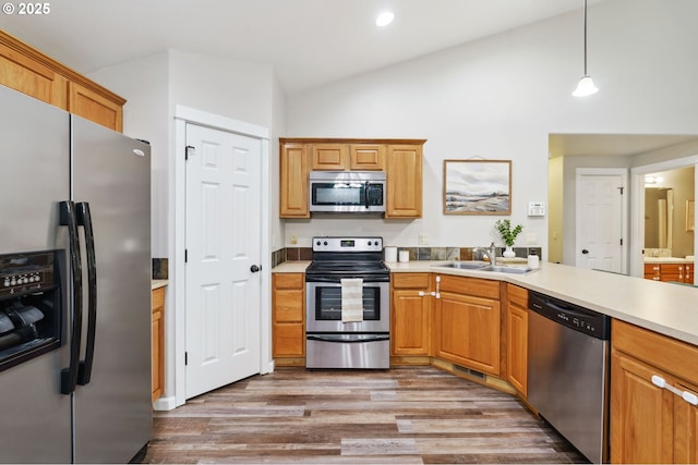 1230 W Fairview Dr, Springfield, OR 97477 - kitchen featuring appliances with stainless steel finishes, high vaulted ceiling, wood finished floors, light countertops, and hanging light fixtures
