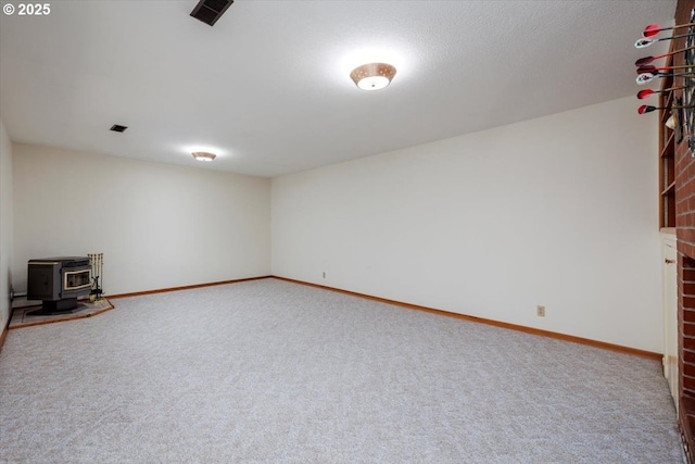 below grade area featuring baseboards, a wood stove, and carpet flooring