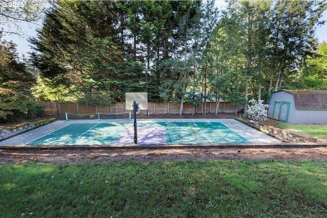 view of pool featuring a tennis court, fence, an outbuilding, and a storage unit