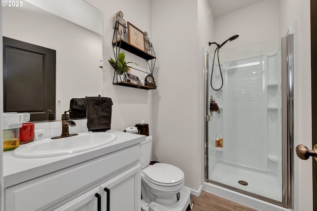 full bathroom with decorative backsplash, toilet, wood finished floors, vanity, and a shower stall