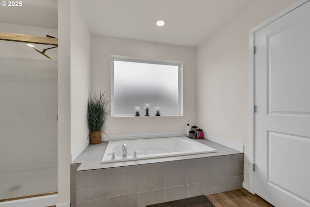 bathroom with wood finished floors, a shower stall, and a bath