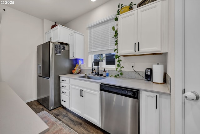 kitchen featuring light countertops, appliances with stainless steel finishes, a sink, and white cabinets