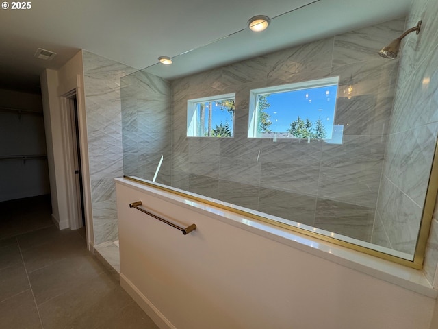 bathroom with walk in shower, tile patterned flooring, a walk in closet, and visible vents