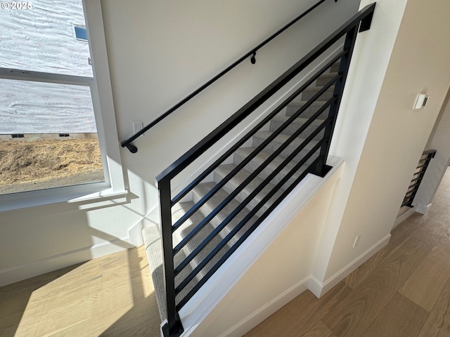 stairway featuring baseboards and wood finished floors