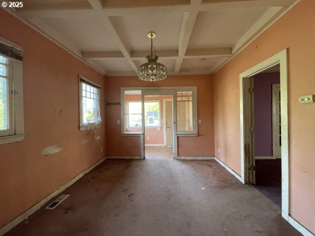 7224 SW 3rd Ave, Portland, OR 97219 - unfurnished dining area featuring a notable chandelier, coffered ceiling, baseboards, visible vents, and beamed ceiling