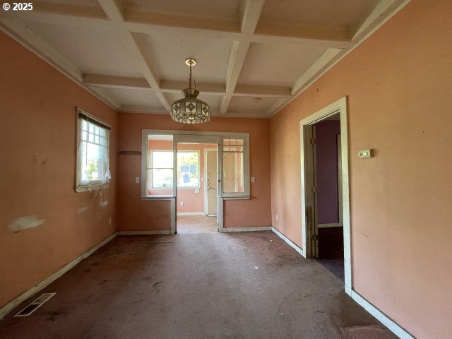 7224 SW 3rd Ave, Portland, OR 97219 - carpeted spare room featuring coffered ceiling, beam ceiling, a chandelier, and baseboards