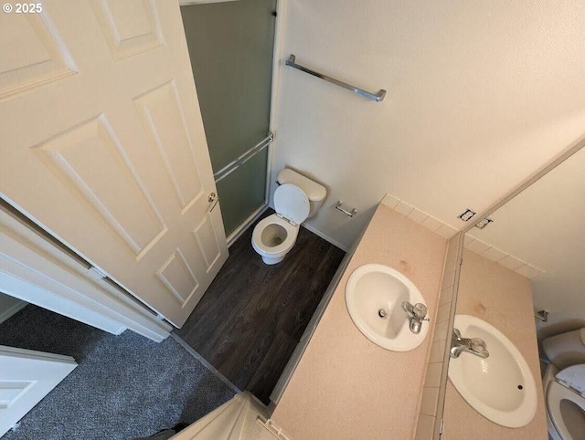 full bath with vanity, wood finished floors, a shower stall, and toilet