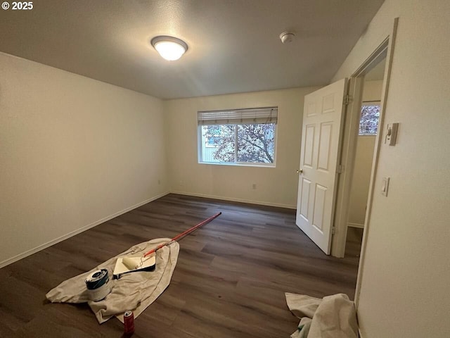 unfurnished bedroom featuring dark wood-style floors and baseboards