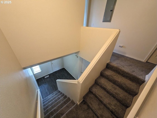 staircase with electric panel and visible vents