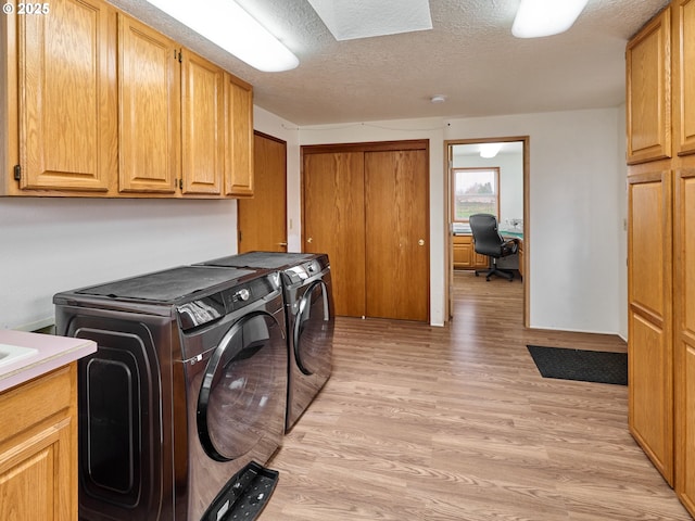 1301 49th Ave, Salem, OR 97317 - laundry room featuring washer and clothes dryer, light wood-style floors, cabinet space, an office area, and a textured ceiling