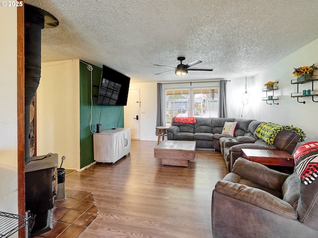 1301 49th Ave, Salem, OR 97317 - living room with a wood stove, ceiling fan, wood finished floors, and a textured ceiling