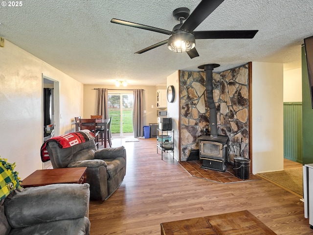 1301 49th Ave, Salem, OR 97317 - living room with a textured ceiling, wood finished floors, ceiling fan, and a wood stove