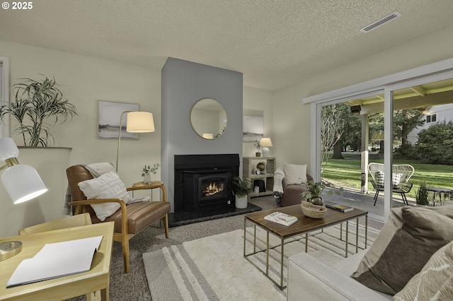 living room with a warm lit fireplace, visible vents, and a textured ceiling