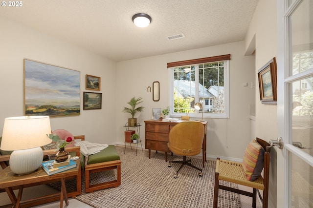 office with a textured ceiling, visible vents, and baseboards