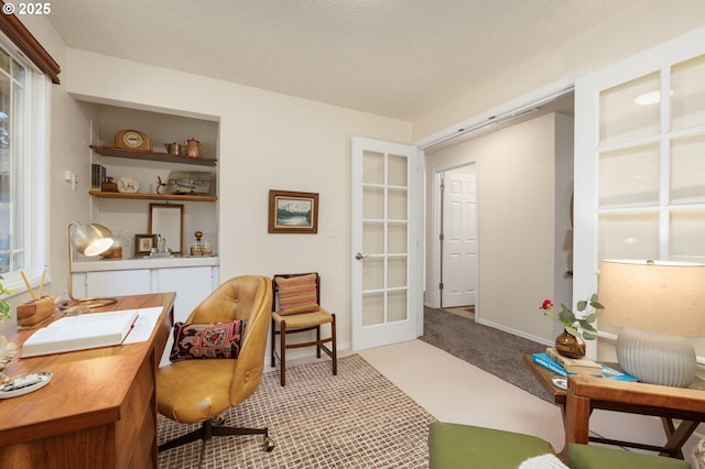 living area featuring a textured ceiling, french doors, carpet, and baseboards