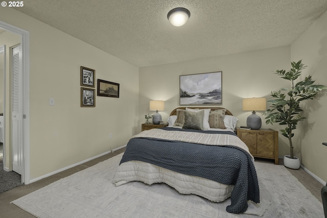 carpeted bedroom featuring a textured ceiling and baseboards