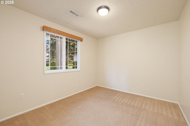 unfurnished room with visible vents, a textured ceiling, baseboards, and carpet flooring