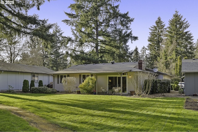 back of house with board and batten siding, a patio area, a lawn, and a chimney