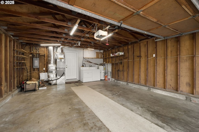 garage with separate washer and dryer, heating unit, electric panel, and a garage door opener