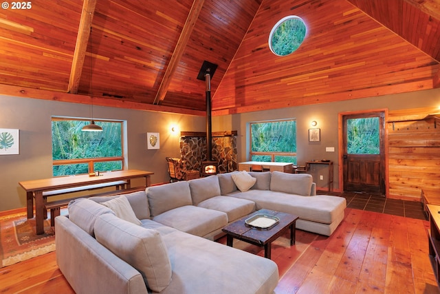 living room with high vaulted ceiling, wood-type flooring, a wood stove, wood ceiling, and beam ceiling