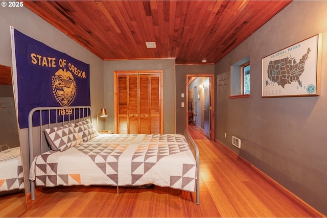 bedroom with wood ceiling, hardwood / wood-style floors, and a closet