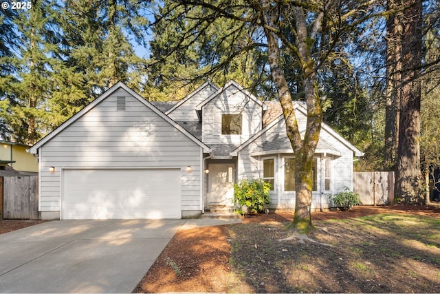 view of front facade with an attached garage, driveway, and fence