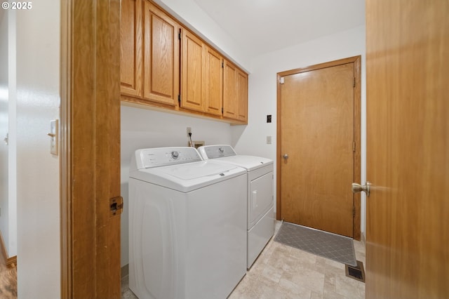 laundry area with washing machine and dryer and cabinets