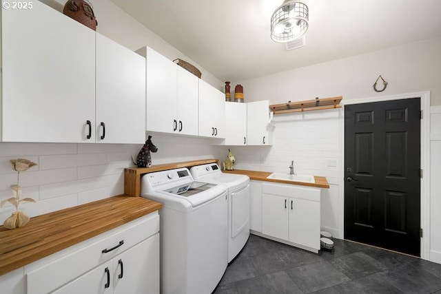 clothes washing area featuring washer and dryer, cabinet space, and a sink