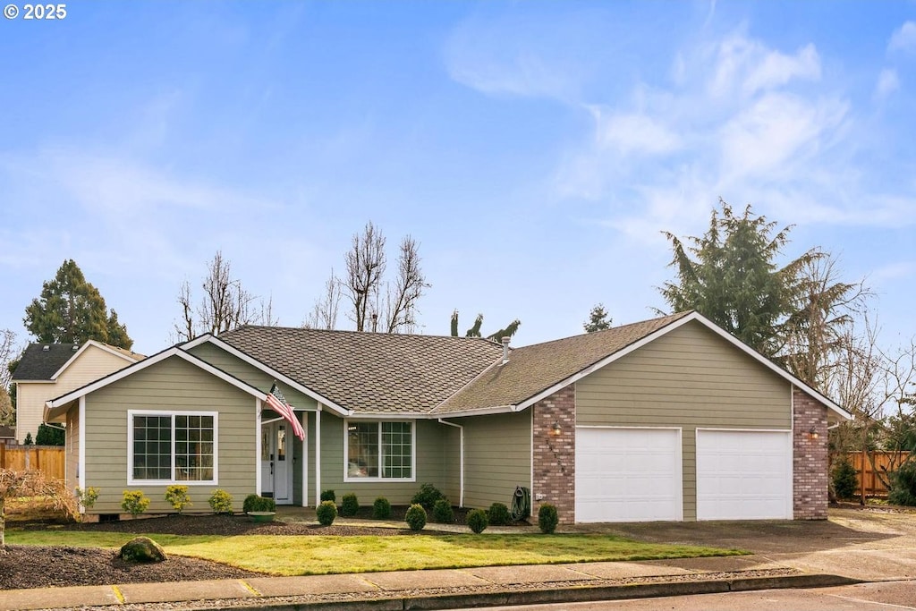 ranch-style home with driveway, a garage, fence, a front lawn, and brick siding