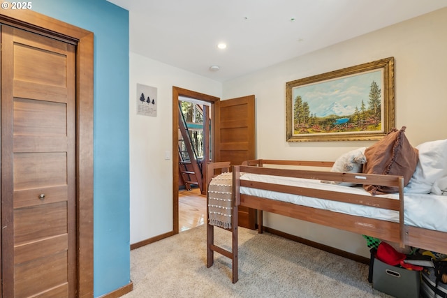 bedroom with baseboards and light colored carpet