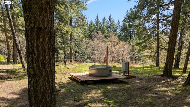 view of yard featuring a view of trees and a deck