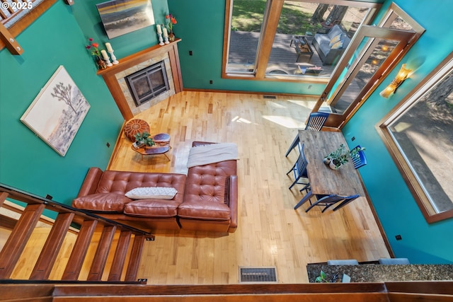 living room featuring visible vents, hardwood / wood-style flooring, and a tile fireplace