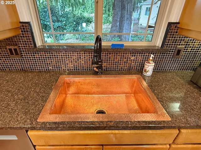 interior details with dark countertops, tasteful backsplash, and a sink