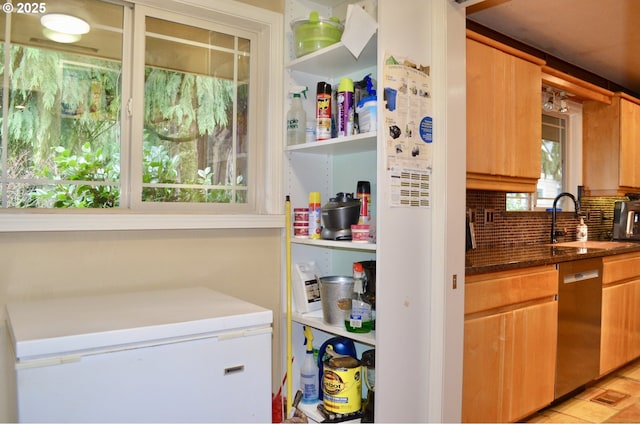 kitchen featuring a sink, tasteful backsplash, dark stone counters, white refrigerator, and dishwasher