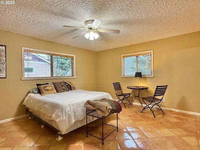 bedroom with baseboards, multiple windows, and a textured ceiling