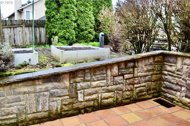 view of patio / terrace with visible vents, a vegetable garden, and fence