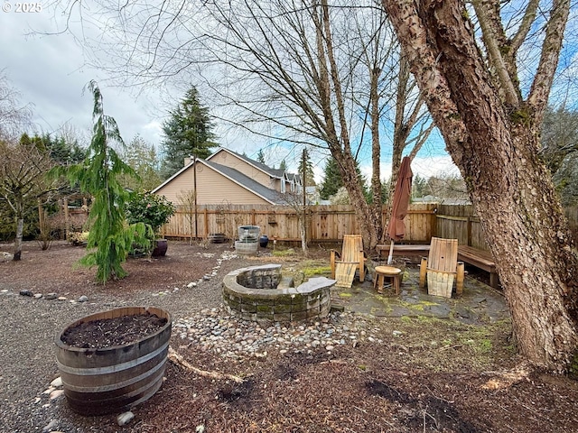 view of yard featuring an outdoor fire pit and fence