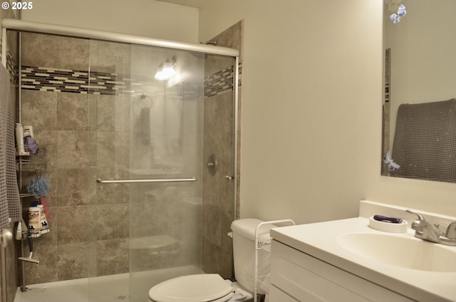 full bathroom featuring a shower stall, toilet, and vanity