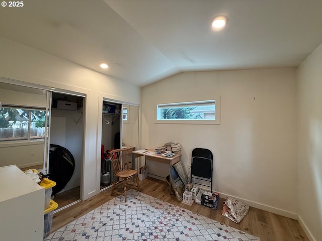 office area with baseboards, a wall unit AC, vaulted ceiling, recessed lighting, and wood finished floors