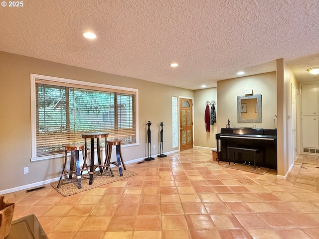 interior space with visible vents, recessed lighting, baseboards, and a textured ceiling