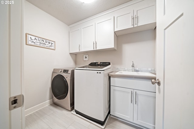 4744 S 19th St, Ridgefield, WA 98642 - washroom with washer and clothes dryer, cabinet space, baseboards, and a textured ceiling