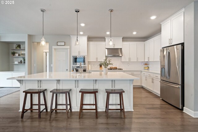 4744 S 19th St, Ridgefield, WA 98642 - kitchen featuring appliances with stainless steel finishes, white cabinetry, under cabinet range hood, decorative backsplash, and light countertops