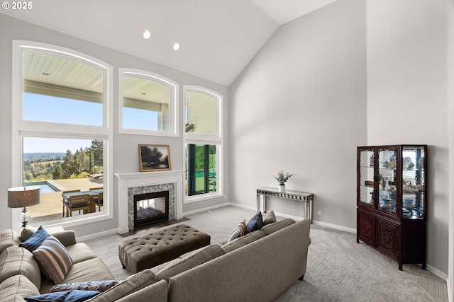 living area with carpet floors, a healthy amount of sunlight, and high vaulted ceiling
